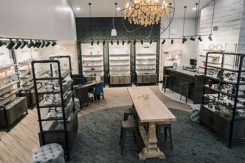 Inside the Haywood Family Eye Care optical: morning sunbeams falling across the frame displays, fitting table and crystal chandelier
